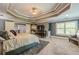 Main bedroom with a luxurious bed, TV, stairway entrance, and sitting area at 4891 Tarry Post Ln, Suwanee, GA 30024