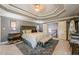 Main bedroom with a luxurious bed, coffered ceiling, and stairway entrance at 4891 Tarry Post Ln, Suwanee, GA 30024