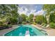 Backyard swimming pool surrounded by lush greenery, lounge chairs, and landscaped areas at 4891 Tarry Post Ln, Suwanee, GA 30024