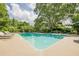 Backyard swimming pool surrounded by lush greenery, lounge chairs, and landscaped areas at 4891 Tarry Post Ln, Suwanee, GA 30024