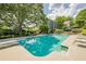 Backyard swimming pool surrounded by lush greenery, lounge chairs, and landscaped areas at 4891 Tarry Post Ln, Suwanee, GA 30024
