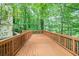 Expansive wooden back deck, perfect for outdoor entertaining, overlooks the lush backyard and wooded area at 5020 Huntshire Sw Ln, Lilburn, GA 30047