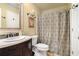 Elegant bathroom featuring a vanity with marble countertop and a shower with a patterned curtain at 5020 Huntshire Sw Ln, Lilburn, GA 30047
