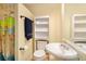Well-lit bathroom showcasing a white vanity, sink, and a shower with a vibrant world map curtain at 5020 Huntshire Sw Ln, Lilburn, GA 30047