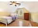 Cozy bedroom featuring a sloped ceiling, wood floors, and a window providing natural light at 5020 Huntshire Sw Ln, Lilburn, GA 30047