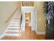 Inviting foyer with hardwood floors, staircase, and a view into the kitchen, with a decorative wreath at 5020 Huntshire Sw Ln, Lilburn, GA 30047