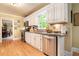 Bright kitchen featuring stainless appliances, granite countertops, and white cabinets with hardwood floors at 5020 Huntshire Sw Ln, Lilburn, GA 30047