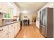 Bright eat-in kitchen featuring granite countertops, stainless steel appliances, and wood floors at 5020 Huntshire Sw Ln, Lilburn, GA 30047