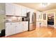 Modern kitchen with stainless steel appliances, granite countertops, and hardwood floors, adjacent to dining room at 5020 Huntshire Sw Ln, Lilburn, GA 30047