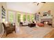 Bright living room with hardwood floors, fireplace, and natural light from large windows at 5020 Huntshire Sw Ln, Lilburn, GA 30047