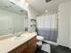 Neutral bathroom featuring a large mirror, single vanity and tub with gray-and-white shower curtain at 115 W Peachtree Nw Pl # 709, Atlanta, GA 30313