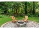 Backyard with a fire pit area, including Adirondack chairs and natural surroundings, perfect for outdoor relaxation at 2106 Penrose Dr, Atlanta, GA 30344