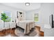 Bright bedroom features two windows, hardwood floors, a neutral color palette, and a comfortable bed at 2106 Penrose Dr, Atlanta, GA 30344