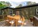 Outdoor wooden deck with a dining table, chairs, and lush greenery in the background at 2106 Penrose Dr, Atlanta, GA 30344