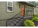 Close-up of home's entry with an orange door, black railings, and tidy landscaping, enhancing curb appeal at 2106 Penrose Dr, Atlanta, GA 30344