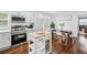 An open kitchen and dining area showcasing stainless steel appliances, light blue cabinets, and a functional kitchen island at 2106 Penrose Dr, Atlanta, GA 30344