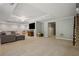 Finished basement with gray sofa, entertainment center, and easy access to the staircase at 4555 Peachtree Dunwoody Rd, Sandy Springs, GA 30342