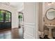 Elegant entryway boasts hardwood floors, detailed trim, and a view into the living space and powder room at 4555 Peachtree Dunwoody Rd, Sandy Springs, GA 30342
