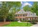 Stately brick home with symmetrical design, dormer windows, lush lawn and manicured landscaping at 4555 Peachtree Dunwoody Rd, Sandy Springs, GA 30342