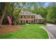 Elegant brick residence featuring classic architecture, a manicured lawn, and a prominent American flag at 4555 Peachtree Dunwoody Rd, Sandy Springs, GA 30342