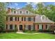 Charming brick home with black shutters, a manicured lawn and lush landscaping at 4555 Peachtree Dunwoody Rd, Sandy Springs, GA 30342