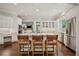 Bright, white kitchen with a large center island, stainless steel appliances, and hardwood floors at 4555 Peachtree Dunwoody Rd, Sandy Springs, GA 30342