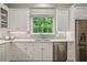 Gourmet kitchen featuring white cabinets, stainless steel appliances, granite countertops, and a window view at 4555 Peachtree Dunwoody Rd, Sandy Springs, GA 30342