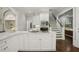 Stylish white kitchen with modern appliances, island cooktop, and direct access to staircase at 4555 Peachtree Dunwoody Rd, Sandy Springs, GA 30342