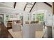 Open-concept living area with vaulted ceilings, exposed beams, fireplace, and seamless flow to dining area at 4555 Peachtree Dunwoody Rd, Sandy Springs, GA 30342