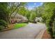 View of two elegant residences, one brick and the other light colored, set on a tree-lined street at 4555 Peachtree Dunwoody Rd, Sandy Springs, GA 30342