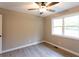 This bedroom has neutral walls, a ceiling fan, and large windows overlooking a green and verdant view at 4665 Jersey Walnut Grove Rd, Covington, GA 30014
