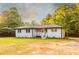 Single-story home featuring a cozy front porch, crisp gray siding, and a well-kept lawn with mature trees in the background at 4665 Jersey Walnut Grove Rd, Covington, GA 30014