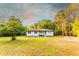 Inviting single-story home with a white porch, surrounded by a lush green lawn and mature trees at 4665 Jersey Walnut Grove Rd, Covington, GA 30014