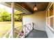 View of a covered front porch with a hanging lantern and white railing overlooking a grassy yard at 4665 Jersey Walnut Grove Rd, Covington, GA 30014
