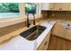 Close up of the kitchen sink showcasing modern fixtures and beautiful countertops at 4665 Jersey Walnut Grove Rd, Covington, GA 30014