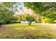 A quaint, well-maintained house sits on a sprawling green lawn, bordered by lush trees at 4665 Jersey Walnut Grove Rd, Covington, GA 30014