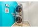 Charming laundry area with stacked washer and dryer, plus vibrant blue accent wall at 4805 Forest Way Ct, Marietta, GA 30066