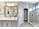 Modern bathroom with walk-in shower, gray vanity, large mirror, and updated lighting fixtures at 606 Broadview Ne Ter, Atlanta, GA 30324