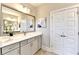 Bathroom featuring double doors, gray vanity, and large mirror with updated lighting fixtures at 606 Broadview Ne Ter, Atlanta, GA 30324