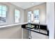 Wet bar featuring a black countertop, stainless steel sink, and bright natural light at 606 Broadview Ne Ter, Atlanta, GA 30324