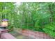 Private backyard view with wooden fence, lush trees, and a charming outdoor lantern at 731 Sacketts Ct, Lawrenceville, GA 30043