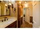 Elegant bathroom featuring brick-style tiling, granite countertops, and dark wood cabinetry at 731 Sacketts Ct, Lawrenceville, GA 30043
