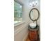Charming powder room featuring a unique vessel sink on a vintage vanity and a round mirror at 731 Sacketts Ct, Lawrenceville, GA 30043
