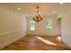 Bright dining room featuring hardwood floors, elegant chandelier, and natural light from the windows at 731 Sacketts Ct, Lawrenceville, GA 30043