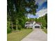Inviting two-story home with lush greenery, a long driveway, and a two-car garage nestled on the corner of a lot at 731 Sacketts Ct, Lawrenceville, GA 30043