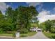 Exterior of the house with a long driveway, surrounded by mature trees on a sunny day at 731 Sacketts Ct, Lawrenceville, GA 30043