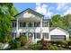 Traditional two-story home with a white brick facade, black shutters, and lush landscaping at 731 Sacketts Ct, Lawrenceville, GA 30043