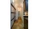 Long hallway with natural stone floors, a sliding door to a pantry and recessed lighting at 731 Sacketts Ct, Lawrenceville, GA 30043