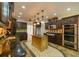This kitchen features dark wood cabinets, stainless steel appliances, an island, and unique lighting at 731 Sacketts Ct, Lawrenceville, GA 30043
