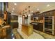 This kitchen features dark wood cabinets, stainless steel appliances, an island, and unique lighting at 731 Sacketts Ct, Lawrenceville, GA 30043
